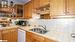 Kitchen with white dishwasher, tile countertops, sink, and backsplash