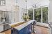 Kitchen featuring white cabinets, blue cabinetry, stainless steel fridge with ice dispenser, and plenty of natural light