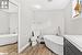 Bathroom featuring toilet, vanity, a bath, and hardwood / wood-style flooring