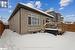 Snow covered rear of property with a deck