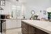 Kitchen with white cabinetry, stainless steel electric range oven, sink, light stone counters, and dark brown cabinets