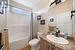 Full bathroom featuring vanity with extensive cabinet space, toilet, shower / bath combo, and tile flooring