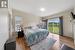 Bedroom featuring baseboard heating, hardwood / wood-style floors, and access to outside