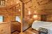 Bedroom with vaulted ceiling with beams, wooden ceiling, wooden walls, and light hardwood / wood-style floors