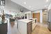 Kitchen featuring stainless steel appliances, white cabinets, rail lighting, sink, and a kitchen island with sink