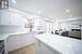 Kitchen featuring white cabinetry, light wood-type flooring, sink, and light stone counters