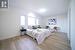 Bedroom with light hardwood / wood-style floors and vaulted ceiling