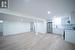 Kitchen featuring light hardwood / wood-style floors, stainless steel refrigerator, ventilation hood, white electric stove, and white cabinets