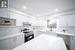 Kitchen featuring white cabinetry, sink, light stone counters, and electric stove