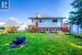 Back of house with a fire pit and a lawn