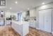 Kitchen with sink, white cabinetry, a center island with sink, appliances with stainless steel finishes, and wall chimney range hood