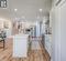 Kitchen with appliances with stainless steel finishes, white cabinetry, sink, a center island with sink, and light hardwood / wood-style flooring