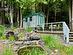 Pond feature with a waterfall and elevated deck area overlooks the pool area.