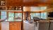 Open concept kitchen/dining/living room with picture windows and gas fireplace overlooking the lake.