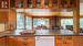 Open concept kitchen/dining/living room with picture windows and gas fireplace overlooking the lake.