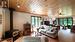 Family room with woodstove and custom wood beam open staircase.