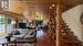 Family room with woodstove and custom wood beam open staircase.