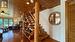 Family room with woodstove and custom wood beam open staircase.