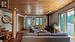 Family room with woodstove and custom wood beam open staircase.