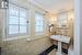 Bathroom with tile walls, tile patterned flooring, and crown molding