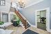 Carpeted entrance foyer with ornamental molding and an inviting chandelier