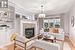 Living room with built in features, a textured ceiling, a tiled fireplace, an inviting chandelier, and light hardwood