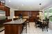 Eat-in kitchen with dark cherry cabinetry topped with granite counters