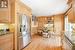 Kitchen featuring appliances with stainless steel finishes, light brown cabinets, stone counters, light wood-type flooring, and decorative backsplash