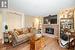 Living room with a brick fireplace, light hardwood / wood-style floors, and a textured ceiling