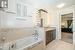 Bathroom with vanity, tile patterned floors, ceiling fan, and tiled tub