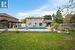 Back of house featuring a gazebo, a patio area, a yard, and a covered pool