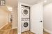 Laundry room featuring light wood-type flooring and stacked washing maching and dryer