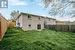 Back of house with a yard and central AC unit