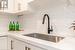 Kitchen featuring decorative backsplash, white cabinetry, and sink