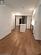 Kitchen with white cabinetry, hardwood / wood-style flooring, and stainless steel fridge