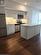 Kitchen with appliances with stainless steel finishes, dark hardwood / wood-style flooring, sink, and white cabinets