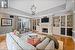 Living room featuring a raised ceiling, crown molding, an inviting chandelier, and light wood-type flooring