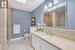 Bathroom with backsplash, a skylight, vanity, tile patterned floors, and toilet