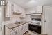 Kitchen featuring range with electric cooktop and white cabinets