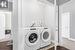 Laundry area with separate washer and dryer and dark hardwood / wood-style flooring