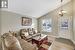 Living room featuring an inviting chandelier, lofted ceiling, and light wood-type flooring