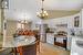 Kitchen with pendant lighting, white cabinets, stainless steel appliances, and a notable chandelier