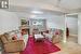 Living room with a tiled fireplace, a textured ceiling, and light wood-type flooring