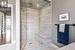 A large glass enclosed steam shower with bench