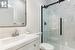 Convenient main floor bathroom with walk-in shower and backlit vanity mirror