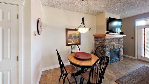 415 O2 - 400 Bighorn Boulevard, Radium Hot Springs, BC - Indoor Photo Showing Dining Room With Fireplace