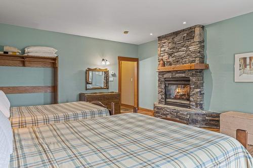 1403 Deer Ridge Road, Golden, BC - Indoor Photo Showing Bedroom With Fireplace