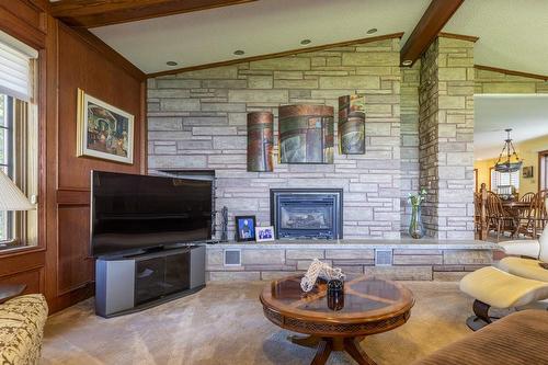 An expansive great room has soaring ceilings and offers a floor to ceiling stone fireplace.  A separate staircase to lower level is also found. - 23 Winona Park Road, Stoney Creek, ON - Indoor Photo Showing Living Room With Fireplace