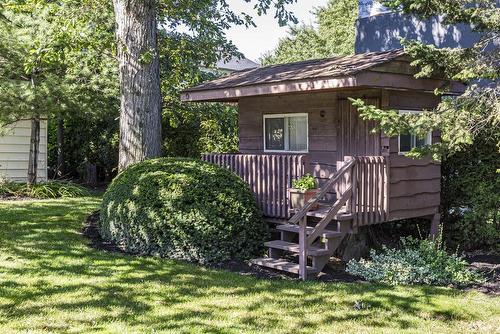 One of two cosy little camp huts which were brought from the campground in the area when it closed.  This one would work well for your little one to act as a lovely little playhouse - 23 Winona Park Road, Stoney Creek, ON - Outdoor With Deck Patio Veranda