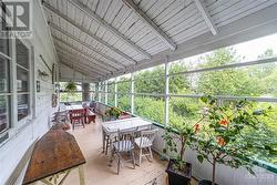 The covered, screened-in porch is a spectacular place to watch the world go by. - 